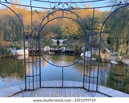 Island with walk under a wrought iron gazebo in a lake in the park