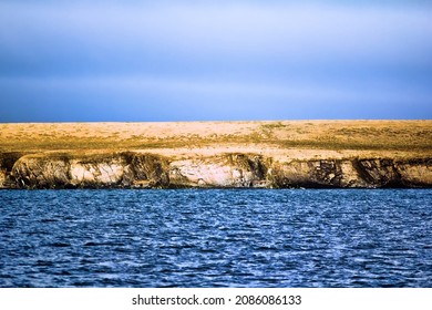 Islands In Arctic Ocean. Coast Of Island Vaigach Near Yugorski Shar Strait: Rocky Cliff And Tundra. Polar Zone, One Of Sites Northeast Passage At White Night (midnight Sun). Russia