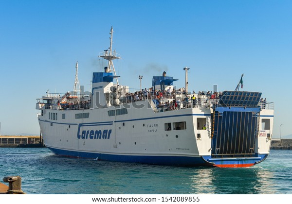 ISLE OF CAPRI, ITALY - AUGUST 2019: Large car\
ferry operated by Caremar reversing to the dockside in the port on\
the Isle of Capri.