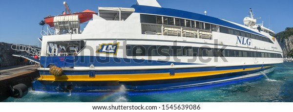 ISLE OF CAPRI, ITALY - AUGUST 2019: Panoramic view\
of a fast ferry operated by NLG docked in the port on the Isle of\
Capri.