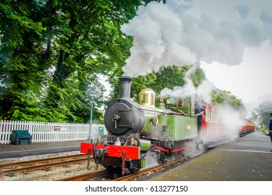 Isle Of Man, Douglas June 2 2016: Steam Train On Railroad Station With Blurred Background. Green Steam Train On Rail Station. Steam Railway Road Isle Of Man.Old Trains Background. Vintage Steam Trains