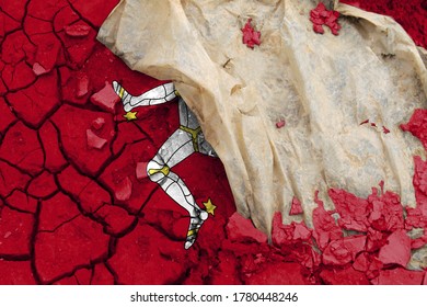 Isle Of Man Flag Is Pictured On Cracked Ground. The Concept Of Ecology With Environmental Pollution From Domestic And Industrial Waste.