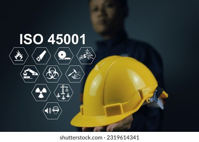 iso 45001 is a workplace safety standard that deals with the health and safety of employees. Standard icons and safety symbols and staff holding helmet to encourage about safety matter