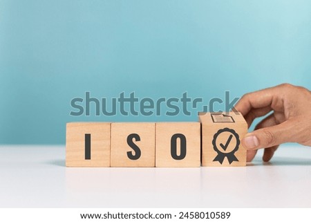 ISO quality control certification, ISO standards verification, Quality certification concept. Hand hold check mark guarantee icon and wooden cubes with the abbreviation ISO