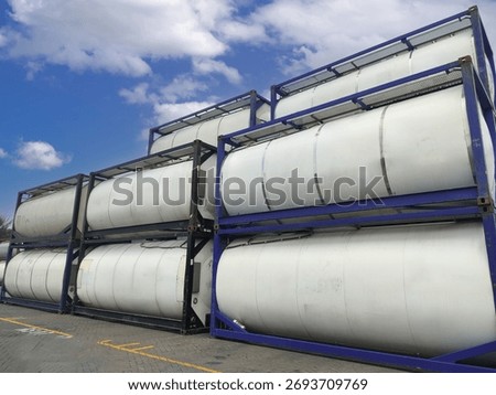 Iso tank container stack at a logistics terminal, featuring multiple cylindrical tanks used for bulk liquid storage and international shipping. Ideal for illustrating themes of global supply chain