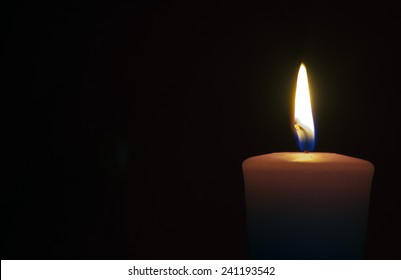 Isolate Burning Candle On Dark Background
