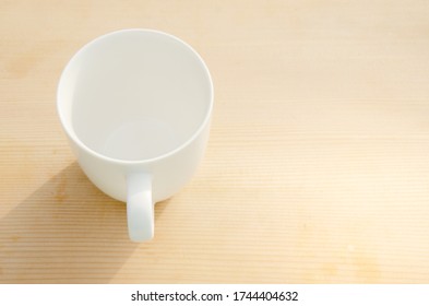 Isolate and close-up​ white cup on smooth wooden table