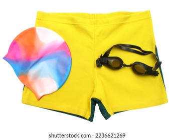 Isolated swimmer’s accessories, includes swimming shorts, multicolor cap, goggles.