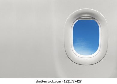 Isolated airplane window with blue sky from customer seat view
