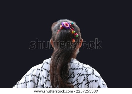 Isolated back of a woman on black background.