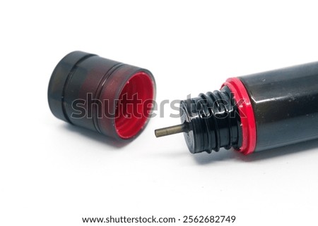 isolated background image of a 60 ML liquid bottle with a transparent black cap in red with a tapered tip