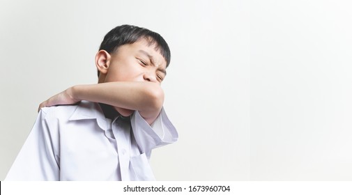 Isolated Banner Of Asian School Kid Boy Children Using Elbow To Cover Face Mouth While Coughing, Concept Of Correct Way For Protection From Corona Virus Disease, Germs And Air Born Transmission