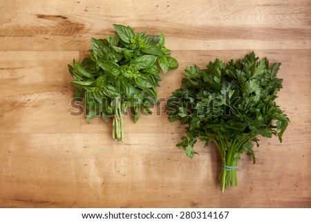 Isolated basil and parsley leaf on a wood background