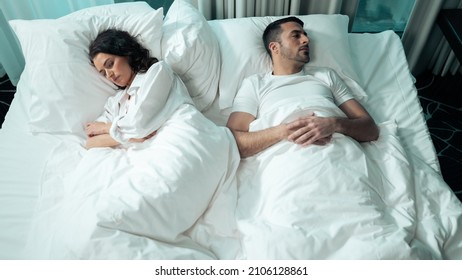 Isolated Beautiful Ethnic Couple Laying In Bed In A Fancy Hotel Suite, Laying With Their Backs To Each Other, Upset And Offended. Female Upset At The Man For Not Gifting Her A Diamond Ring.