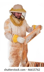 An Isolated Beekeeper Inspecting A Frame Of Honey