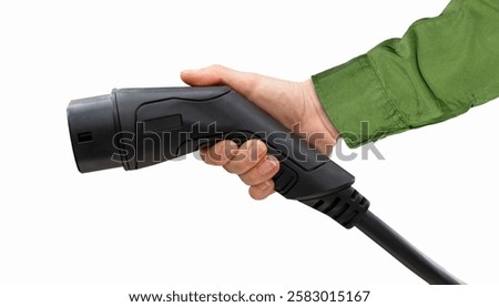 Isolated black EV charging plug in female hand. Electric car charging connector.	