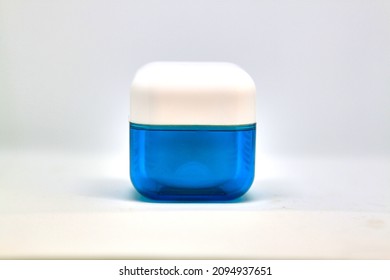 Isolated blue vial for cosmetic cream on white background, face skin care. Selective focus. High quality photo
