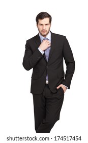 isolated businessman fixing his tie