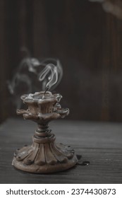 Isolated candle on black with vintage retro candle holder emitting a smoke - Shutterstock ID 2374430873