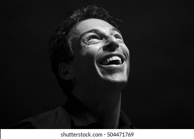 Isolated Caucasian Man Face Laughing . Black Background, Black And White Picture