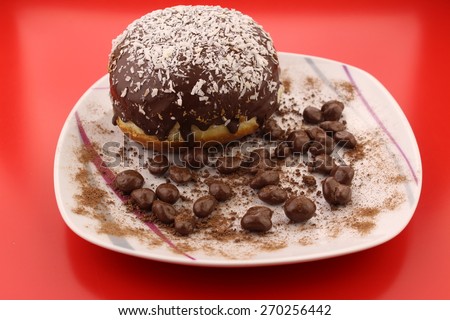 Isolated chocolate donut and chocolate balls with cocoa powder on a plate 