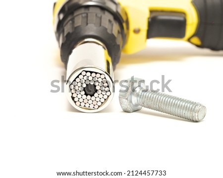 Isolated chrome universal socket wrench able to open different sized bolts. Cordless screwdriver, Selective focus.