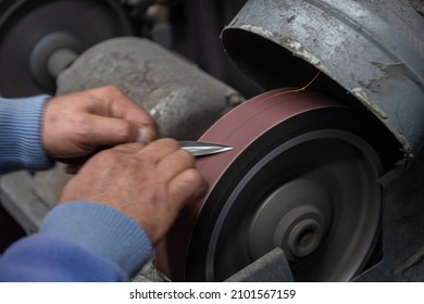 Isolated Close Up Of Chef Knife Sharpening, Honing And Stropping Process By  A Skilled Craftsman. Vintage Old School Craftsman At Work In Grange Shop Showing True Professional Skills.