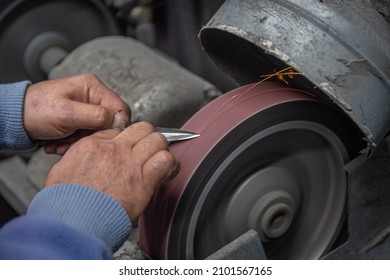 Isolated Close Up Of Chef Knife Sharpening, Honing And Stropping Process By  A Skilled Craftsman. Vintage Old School Craftsman At Work In Grange Shop Showing True Professional Skills.