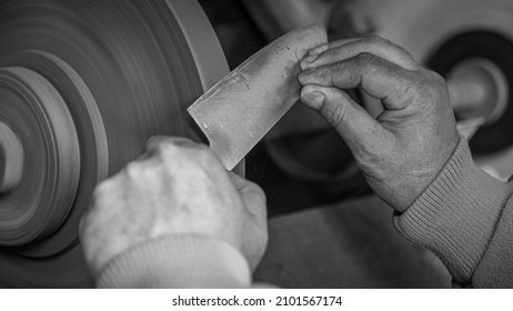 Isolated Close Up Of Chef Knife Sharpening, Honing And Stropping Process By  A Skilled Craftsman. Vintage Old School Craftsman At Work In Grange Shop Showing True Professional Skills.