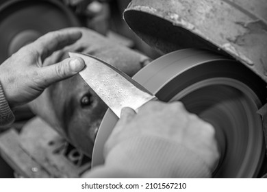 Isolated Close Up Of Chef Knife Sharpening, Honing And Stropping Process By  A Skilled Craftsman. Vintage Old School Craftsman At Work In Grange Shop Showing True Professional Skills.