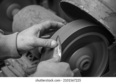 Isolated Close Up Of Chef Knife Sharpening, Honing And Stropping Process By  A Skilled Craftsman. Vintage Old School Craftsman At Work In Grange Shop Showing True Professional Skills.