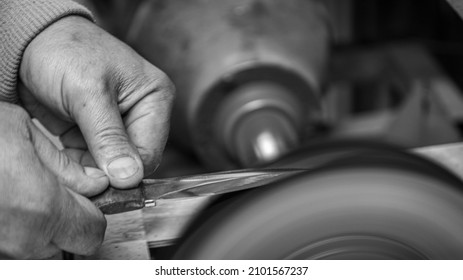 Isolated Close Up Of Chef Knife Sharpening, Honing And Stropping Process By  A Skilled Craftsman. Vintage Old School Craftsman At Work In Grange Shop Showing True Professional Skills.