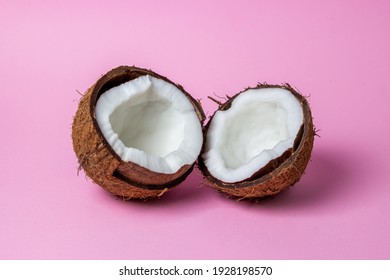 Isolated coconut on a pink background. The two halves of the coconut are in the center of the image. Healthy fruit