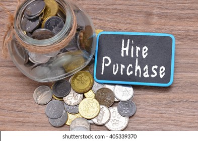 Isolated Coins In Jar With Hire Purchase Word On Mini Chalkboard - Financial Concept