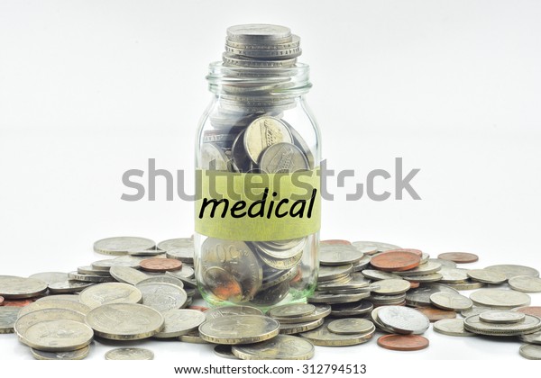 Isolated coins in jar with medical label -\
financial concept