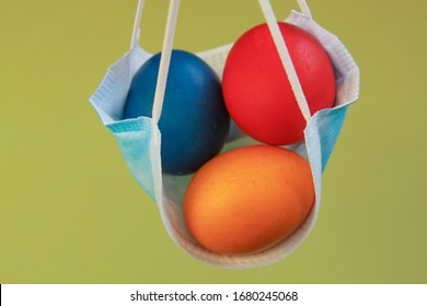 Isolated colored painted Easter eggs in surgical mask, a symbol of coronavirus pandemic. Safety first while celebrating Easter 2020 covid 19 outbreak concept for quarantine holiday in self isolation.
