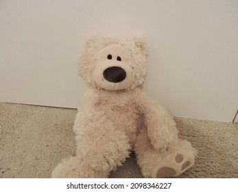 An Isolated Cream Teddy Bear Left Against A Childrens Bedroom Wall