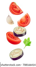 Isolated Cut Vegetables. Raw Slices Of Eggplant, Tomato And Garlic Flying In The Air Isolated On White Background With Clipping Path