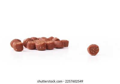 Isolated dog treat with defocused pile of treats. Mini training treat sizes ideal for dog obedience, repetitive tricks and reward. Beef and bacon flavor dog snack. Selective focus. White background.