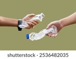 Isolated empty and twisted plastic bottles of drinking water holding in hands with clipping paths, eco friendly and environment care concept.