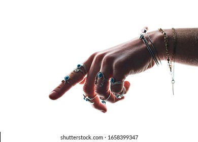 Isolated female hand of boho style wearing  silver rings with turquoise stone and bracelets on a white background. Womens jewelry and bijouterie 