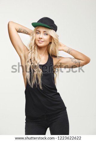 isolated female portrait with clean and smooth armpit in stylish clothes and tattoos with confident expression. vertical shot of stylish woman.