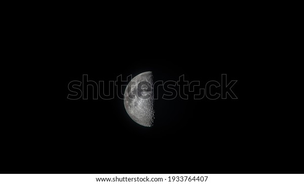 Isolated first quarter\
moon in the dark