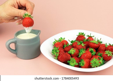 An Isolated Fresh Strawberry Being Dipped In To Thick Double Cream