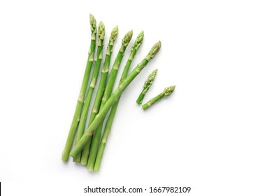 Green asparagus bunch on wicker tray on white table background