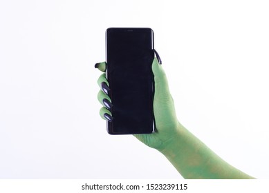 Isolated Halloween Green Witch Hand Holding Black Mobile Phone On White Background