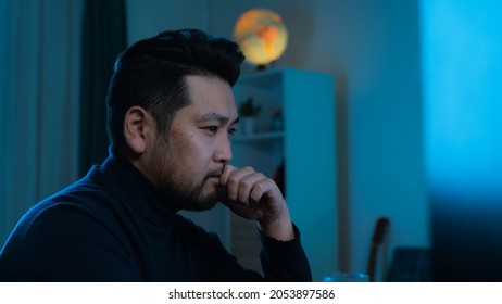 Isolated Handsome Asian Animator Side Profile As He Is Developing A New Modern Website. Graphic Designer Working Hard At His New Project In A Moody Dark Office Space, Wearing A Fancy Dark Turtleneck.