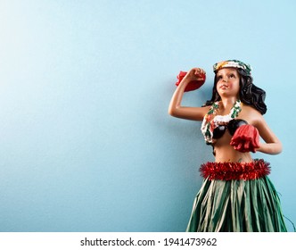 Isolated Hula Girl Doll Against Bright Light Blue Background With Copy Space
