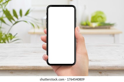 Isolated Human Right Hand Holding Black Mobile Smart Phone Device Mockup In Kitchen