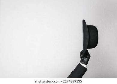 Imagen aislada del sombrero Bowler de cuero con la mano amada cortésmente. El mayordomo británico clásico o el empresario británico. Copiar espacio para la industria de servicios.